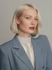 Blond woman in blue blazer and white shirt.